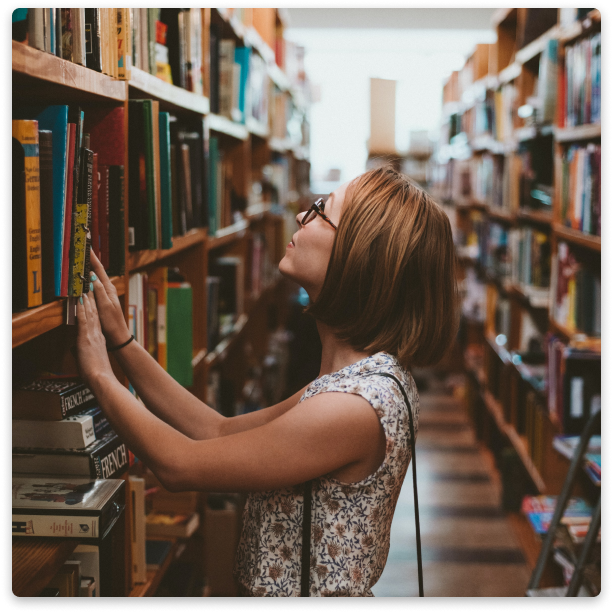 A person looking at books in a library